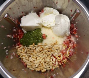 Parmesan, Ricotta, Pesto und Pinienkerne untermischen