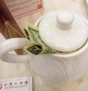 Trinkgeld stilecht unter den Teekannen-Deckel klemmen